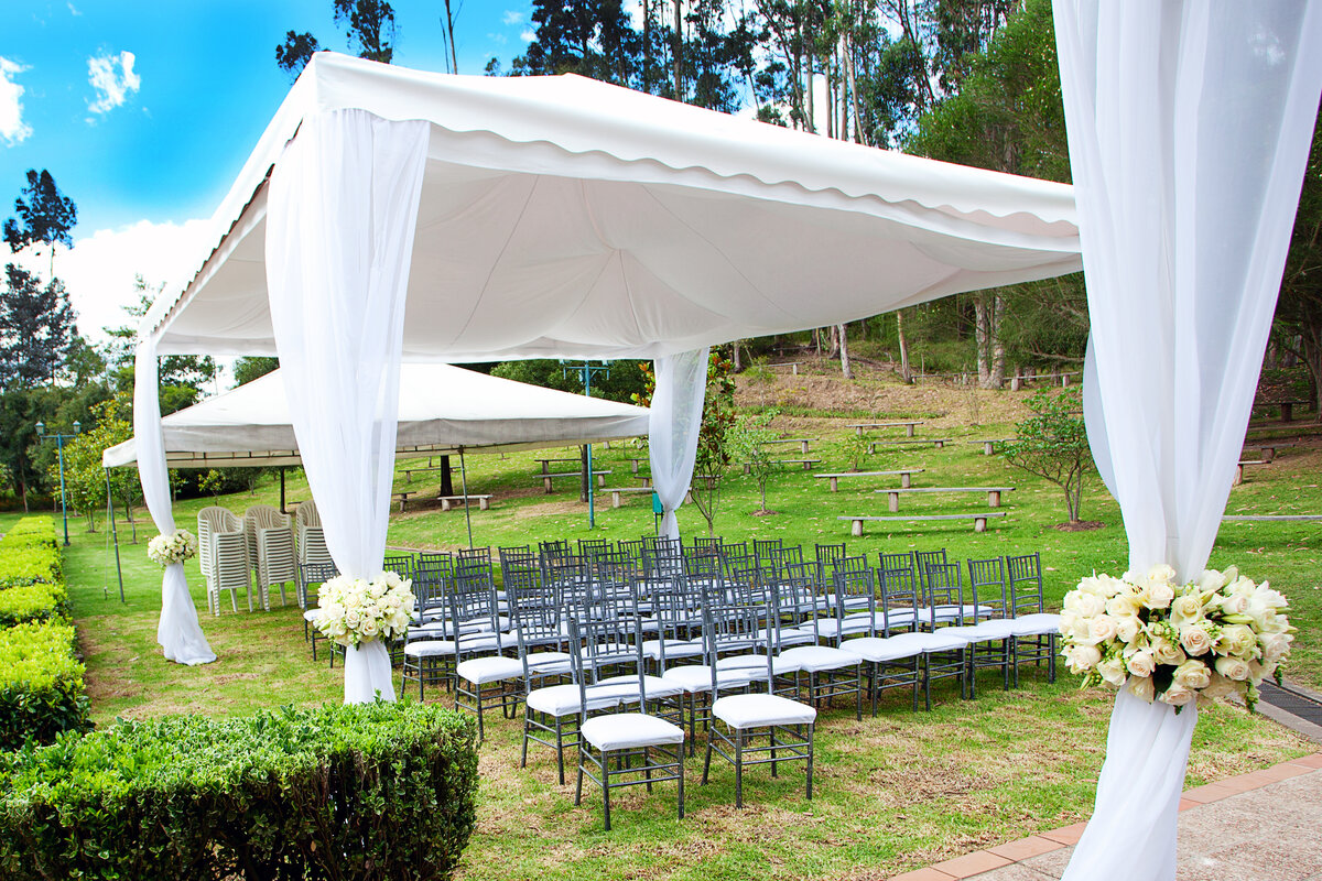 Hochzeitspavillon in einem grünen Park mit Stuhlreihen
