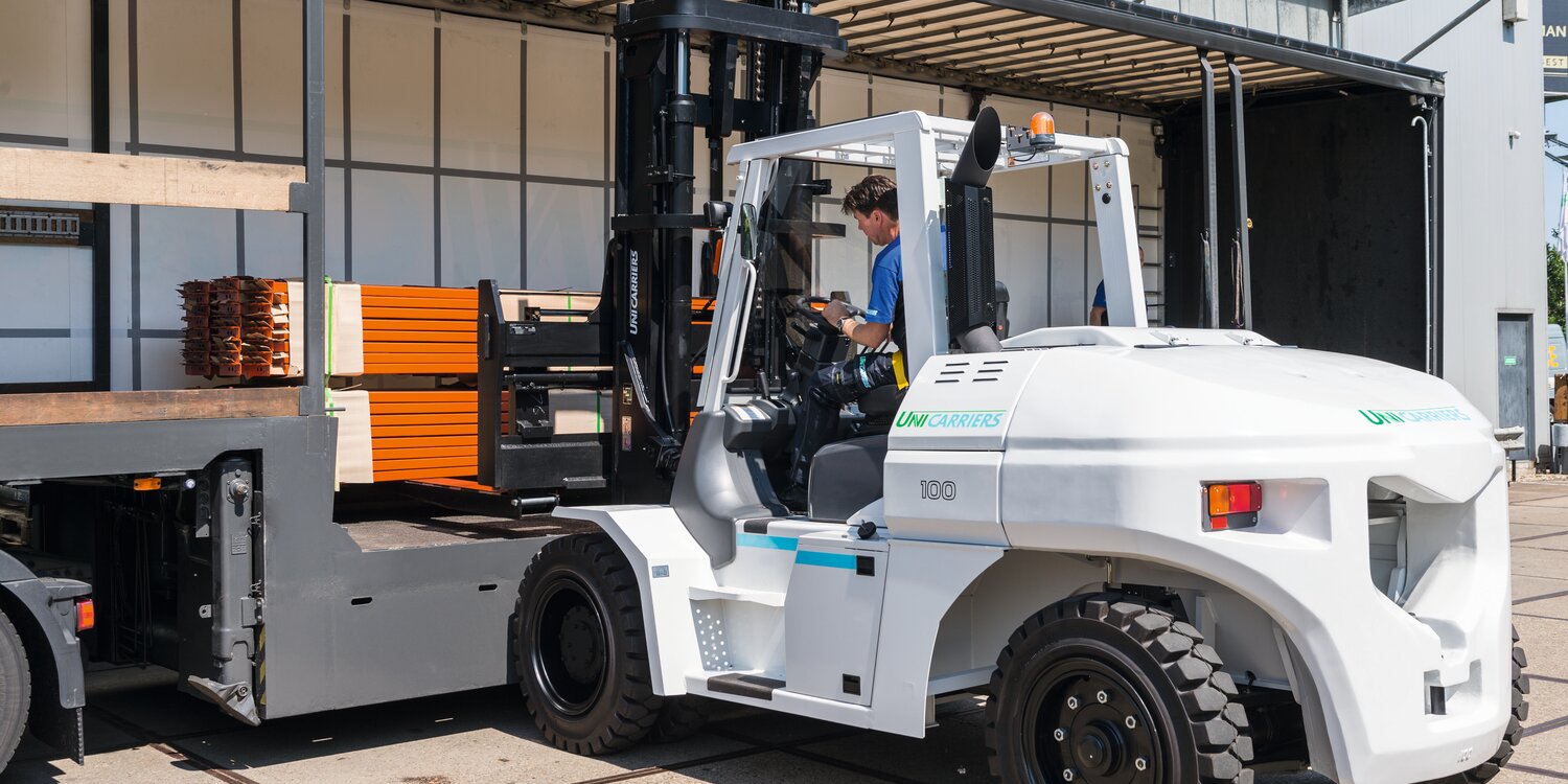 Fahrer in UniCarriers Gabelstapler beim Aufladen von Paletten auf einen Lkw