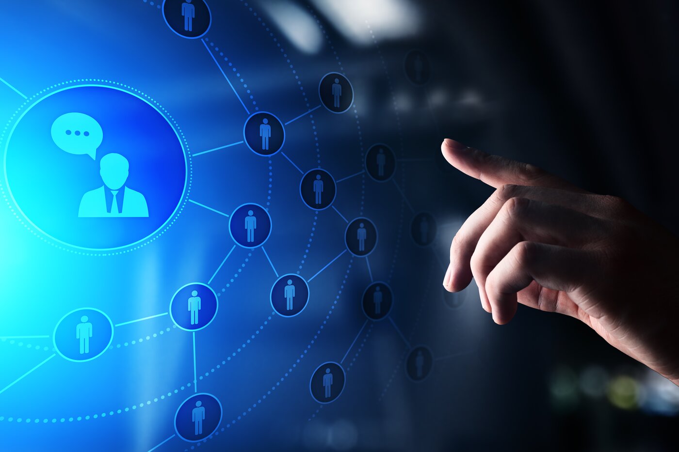 Zeigefinger der linken Hand, der von rechts auf ein Hologramm mit einem Gitter aus miteinander vernküpften Männchen zeigt